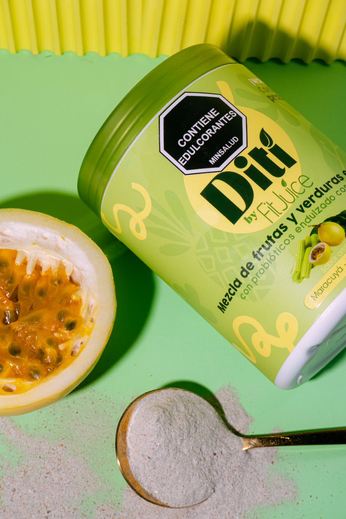 Diti by Fit&Juice container with a spoonful of powder and a passion fruit on a green background
