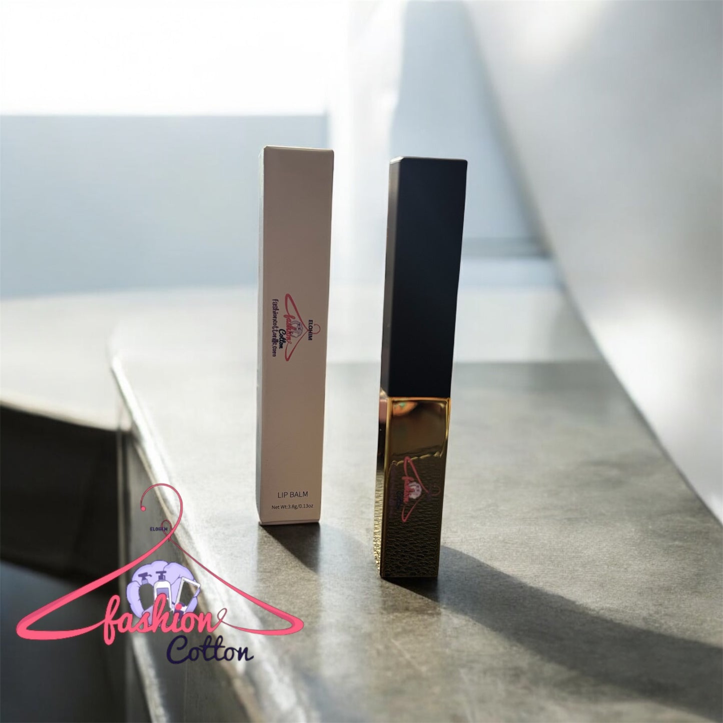 Lip balm and packaging on a reflective surface with 'Fashion Cotton' branding.